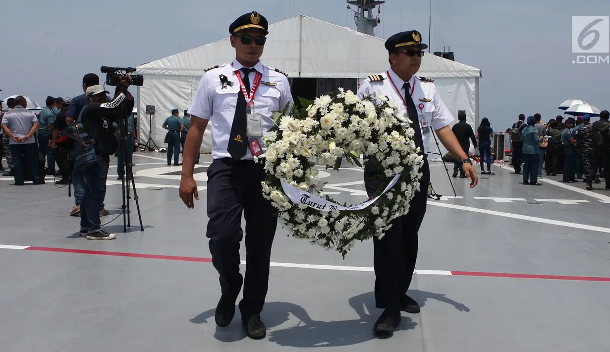Crew pesawat Lion Air  membawa karangan bunga di atas KRI Banda Aceh di Perairan Tanjung karawang, Jabar, Selasa (6/11). Pesawat Lion Air JT 610 jatuh di Tanjung Karawang, Jabar, Senin (29/10/2018) pagi. (Merdeka.com/Imam Buhori)