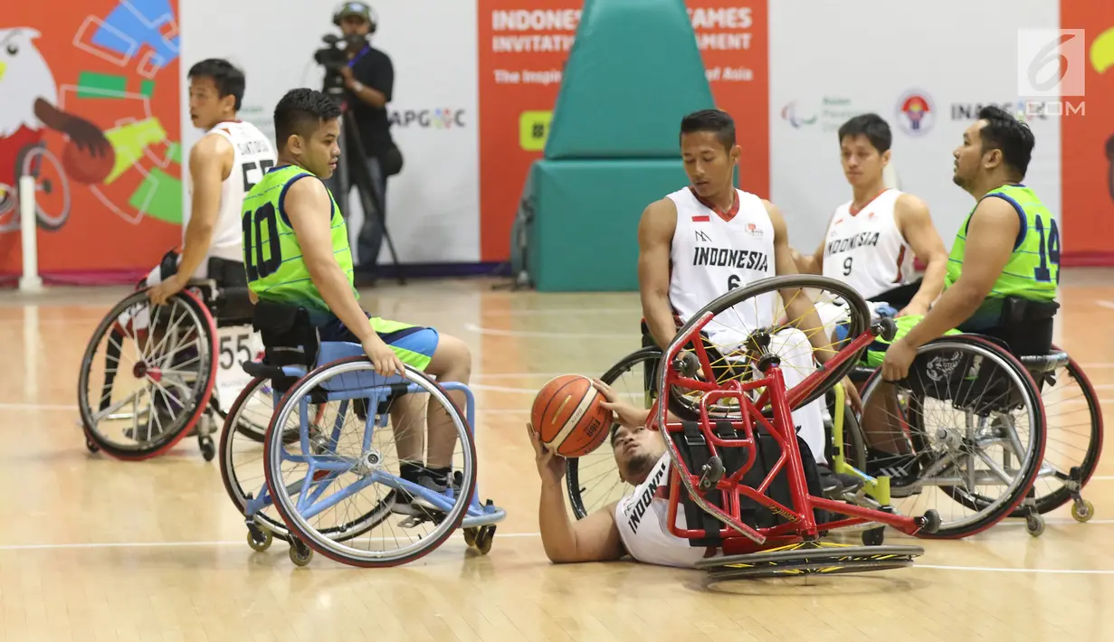 Pebasket difable Indonesia, Kasep Ayatulloh terjatuh saat berebut bola dengan pemain Malaysia pada laga Indonesia Para Games Invitational Tournament 2018 di Hall A Senayan, Jakarta, Minggu (1/7). Indonesia unggul 54-53. (Liputan6.com/Helmi Fithriansyah)