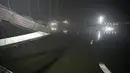 Tim penyelamat di kapal mencari di sungai Machchu di sebelah jembatan kabel yang runtuh di kota Morbi di negara bagian barat Gujarat, India, Senin, 31 Oktober 2022. Sedikitnya 81 orang tewas akibat kejadian tersebut. (AP/Ajit Solanki)