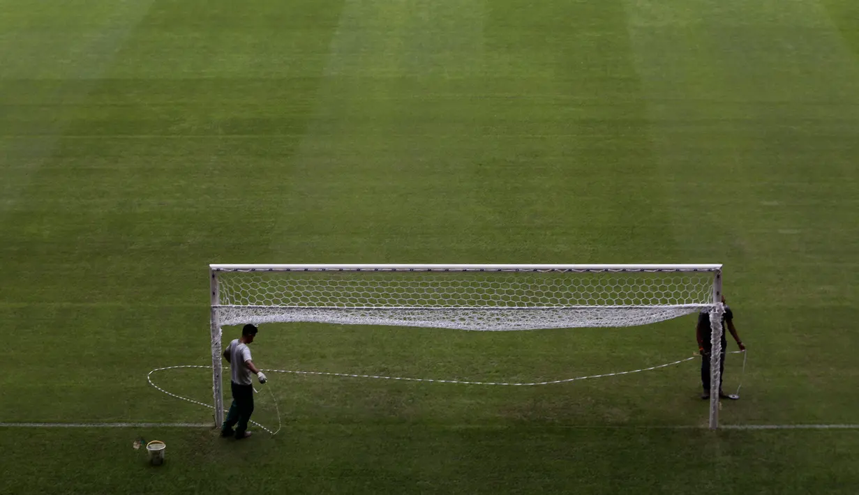 Pekerja mempersiapkan National Stadium untuk turnamen sepak bola Copa America di Brasilia, Brasil, Jumat (11/6/2021). Copa America 2021 akan dibuka dengan laga dari Grup A, antara Brasil vs Venezuela, pada 13 Juni waktu setempat atau 14 Juni dini hari WIB. (AP Photo/Eraldo Peres)