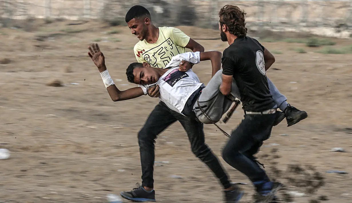 Wanita Palestina memakai ketapel untuk melemparkan batu ke arah pasukan Israel saat bentrok di Khan Yunis, Jalur Gaza, Jumat (13/9/2019). Unjuk rasa Great March of Return ini sudah masuk pekan ke- ke-74. (SAID KHATIB/AFP)