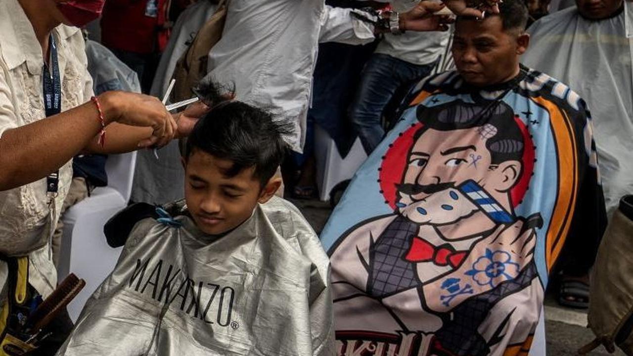 Kegiatan potong rambut massal ini diikuti semua kalangan baik orang dewasa hingga anak-anak. Foto: AFP / Juni Kriswanto