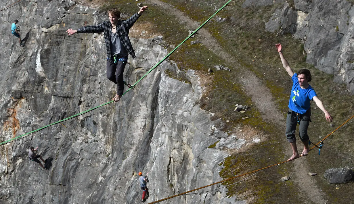 Peserta berjalan diatas tali saat mengikuti festival slackline , di sebuah tambang dekat Beroun, Republik Ceko (25/3). Slackline adalah olahraga keseimbangan di atas tali, yang talinya tersebut dikencangkan di antara dua titik. (AFP/Michal Cizek)