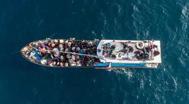 Pengungsi etnis Rohingya berada di atas kapal milik nelayan Indonesia di pesisir Pantai Seunuddon, Aceh Utara (24/6/2020). Sebanyak 94 pengungsi etnis Rohingya yang lelah dan kelaparan, termasuk 30 anak-anak ditemukan terdampar di pesisir Pantai Seunuddon. (AP Photo/Zik Maulana)