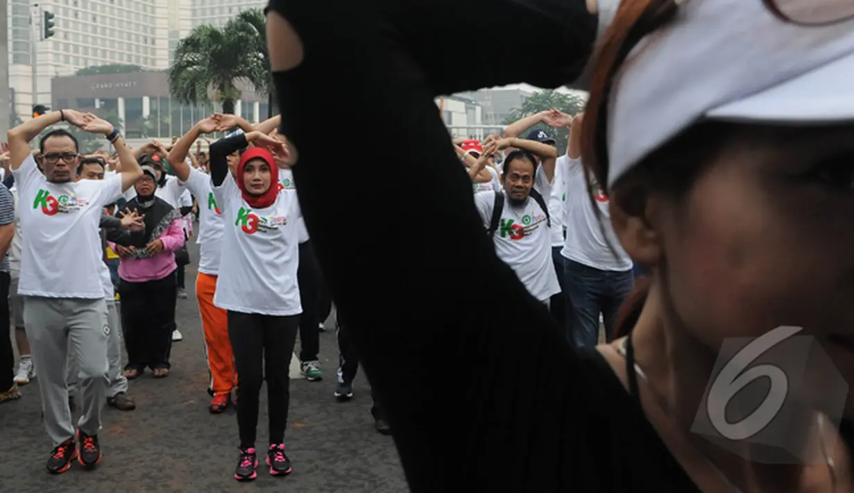 Menteri Hanif Dhakiri didampingi istri Marifah melakukan senam di Bundaran HI, Jakarta, Minggu (1/3/2015). Kegiatan tersebut untuk meningkatkan kesadaran masyarakat akan pentingnya Keselamatan dan Kesehatan Kerja (K3). (Liputan6.com/Herman Zakharia)