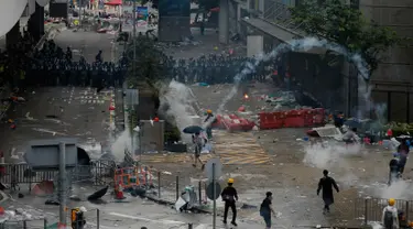 Polisi anti huru hara menembakkan gas air mata ke arah demonstran di luar gedung Dewan Legislatif, Hong Kong, Rabu (12/6/2019). Polisi Hong Kong telah menggunakan gas air mata ke arah ribuan demonstran yang menentang RUU ekstradisi yang sangat kontroversial. (AP Photo/Vincent Yu)