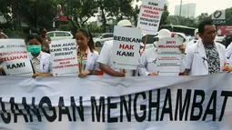 Sejumlah massa yang menamakan diri dari Pergerakan Dokter Muda Indonesia membentangkan spanduk saat melakukan aksi di depan Istana Negara, Jakarta, Kamis (19/7). (Liputan6.com/Johan Tallo)