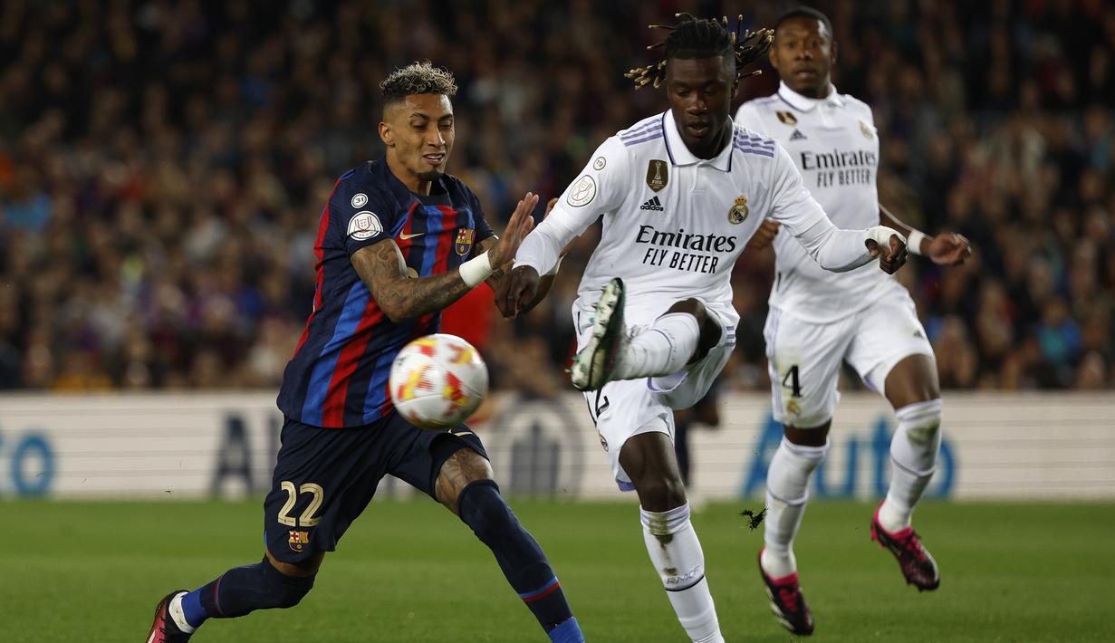 Gelandang Real Madrid, Eduardo Camavinga (kanan) berebut bola dengan striker Barcelona, Raphinha pada laga leg kedua semifinal Copa del Rey 2022/2023 di Camp Nou Stadium, Barcelona, Kamis (6/4/2023) dini hari WIB. (AP Photo/Joan Monfort)