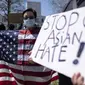 Lucy Lee memegang bendera Amerika saat unjuk rasa "Stop Asian Hate" di luar Gedung Kongres Georgia di Atlanta, Sabtu (20/3/2021). Ratusan demonstran berkumpul mendukung komunitas Asia-Amerika setelah penembakan di tiga tempat spa yang menewaskan 8 orang, termasuk 6 wanita Asia. (AP Photo/Ben Gray)
