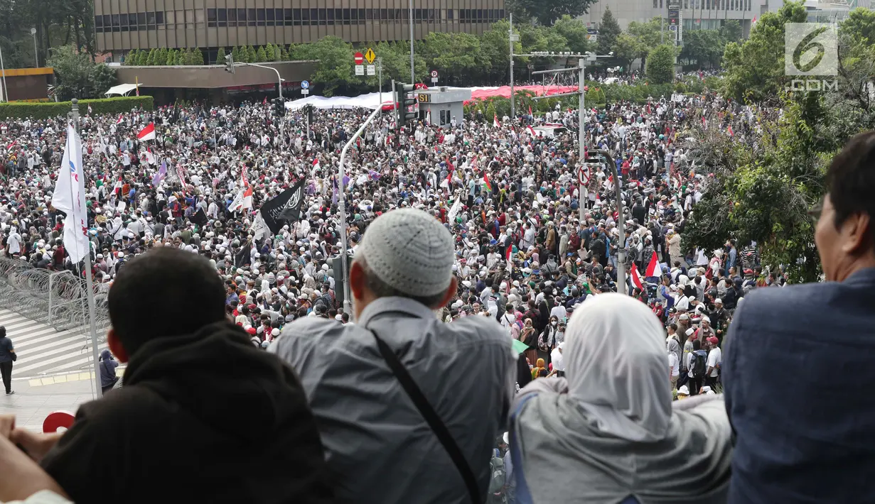 Warga melihat kerumunan peserta aksi massa Gerakan Nasional Kedaulatan Rakyat yang melakukan unjuk rasa di perempatan dekat Gedung Bawaslu, Jakarta, Rabu (22/5/2019). Dalam aksinya, mereka meminta Bawaslu memeriksa kembali hasil Pemilu 2019. (Liputan6.com/Helmi Fithriansyah)