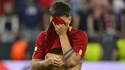 Paulo Dybala berkali-kali tertangkap kamera menutup wajahnya dengan jersey yang dia kenakan. Dia terlihat mengusap air matanya. (AP Photo/Denes Erdos)