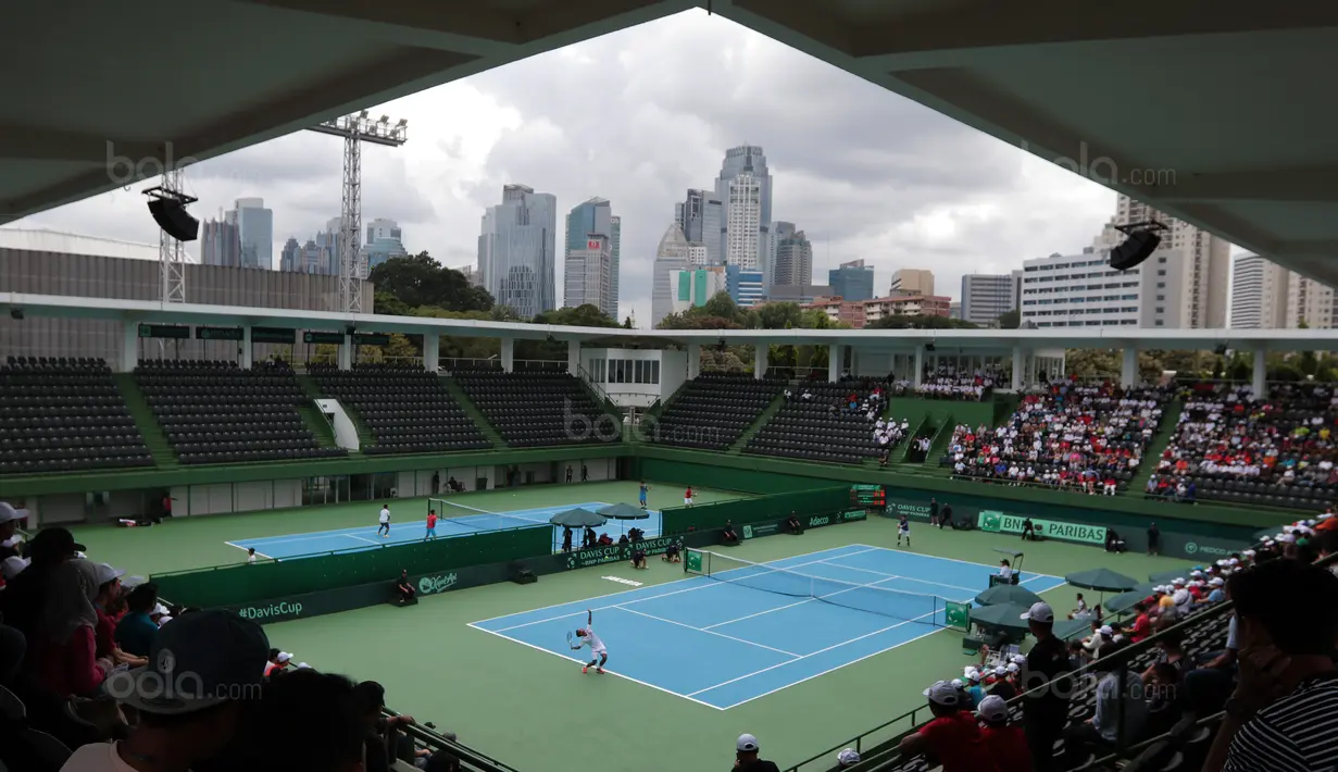 Aksi petenis Indonesia, Althaf Dhaifullah melakukan servis saat melawan petenis Fiipina Davis 2018 grup dua Asia/Oceania di Senayan, Jakarta, Sabtu (3/2/2018). Althaf kalah 3-6, 2-6. (Bola.com/Nick Hanoatubun)