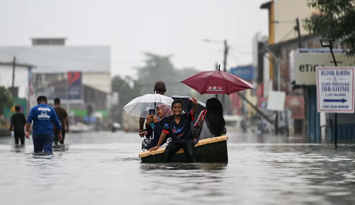 Banjir juga memaksa puluhan ribu orang mengungsi. (MOHD RASFAN/AFP)