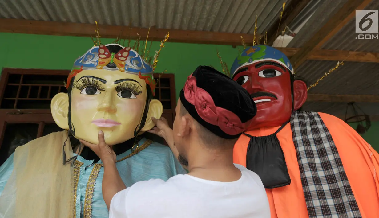 Perajin memasang kepala ondel-ondel Betawi ukuran besar saat proses pembuatan di Serpong, Tangerang Selatan, Banten, Rabu (10/10). Harga kerajinan ondel-ondel tergantung dengan dari ukurannya. (Merdeka.com/Arie Basuki)