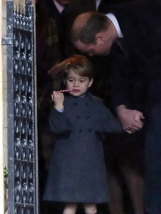 Pangeran William menggandeng tangan sang putra, Pangeran George usai mengikuti Misa Natal di Gereja St Mark, Englefield, Inggris, Minggu (25/12). Pangeran George tampak menggemaskan dalam balutan coat abu-abu.  (REUTERS/Andrew Matthews/Pool)
