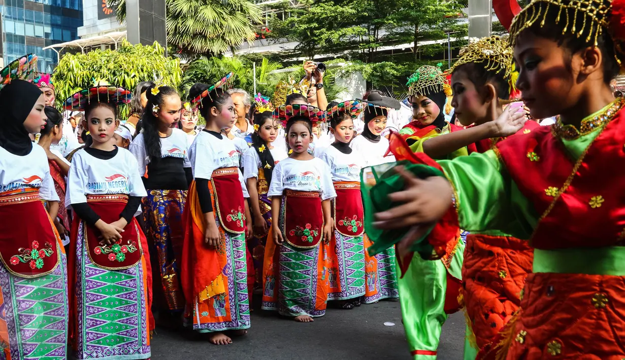 Peserta flashmob tengah bersiap membawakan tarian tradisional di kawasan Senayan Jakarta, Minggu (21/8). Anak-anak hingga orang dewasa antusias mengikuti kegiatan yang digagas Yayasan Belantara Budaya Indonesia. (Liputan6.com/Fery Pradolo)