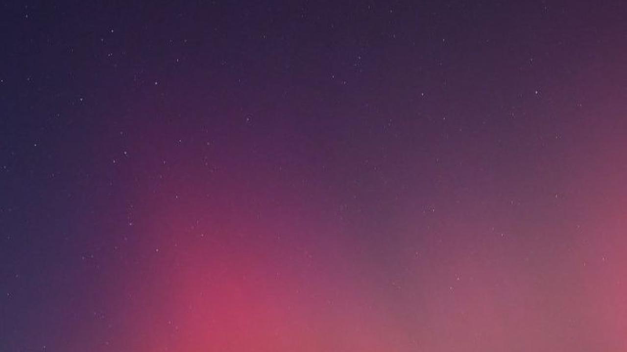Aurora Australis dengan pancaran cahaya hijau, jingga, merah, dan ungu ini dipicu oleh badai Matahari ekstrem.