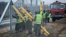 Narapidana menyelesaikan pemasangan pagar anti-imigran kedua di perbatasan Hungaria - Serbia, dekat Kelebia, 1 Maret 2017. Hungaria merupakan negara yang menjadi titik persimpangan utama bagi ratusan imigran yang menuju ke Eropa (Sandor Ujvari/MTI via AP)