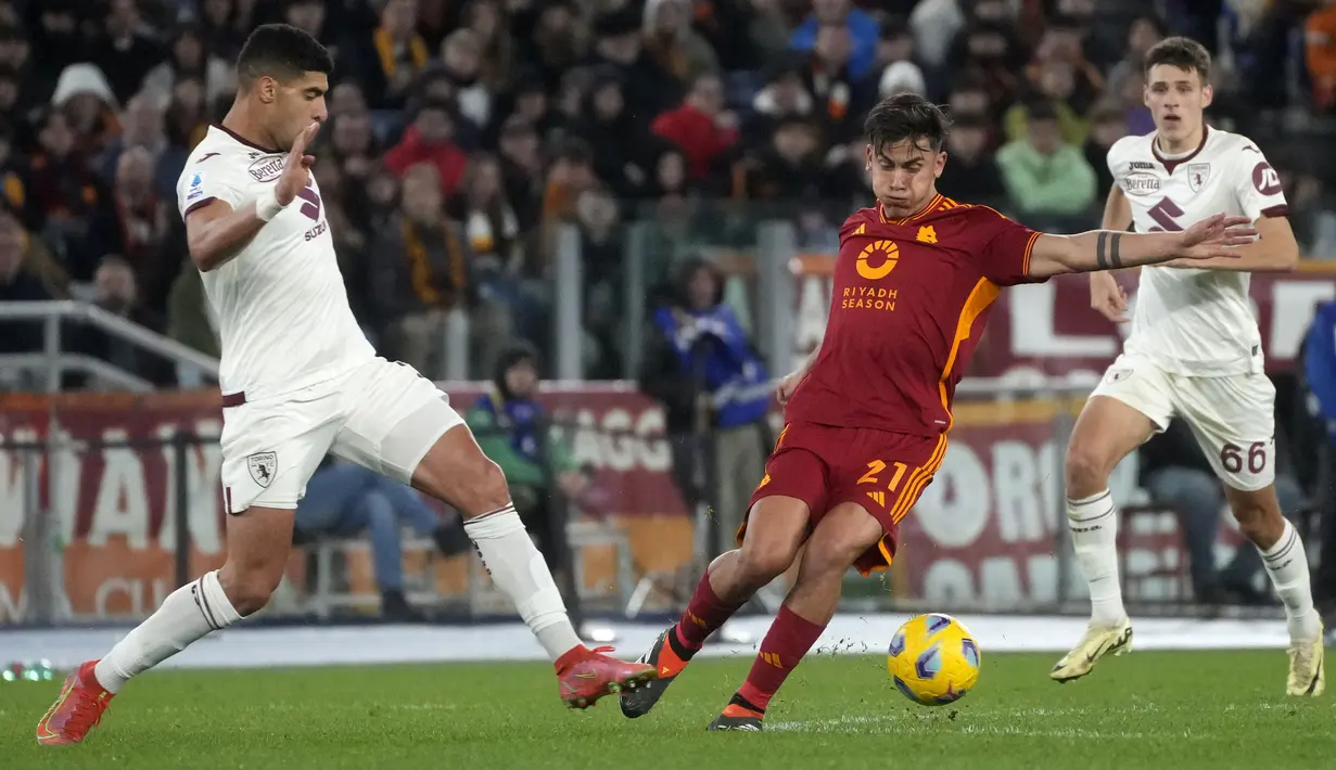 Pemain AS Roma, Paulo Dybala (tengah) berusaha melewati penjagaan pemain Torino, Adam Masina saat laga lanjutan Liga Italia 2023/2024 di Olympic Stadium, Roma, Italia, Selasa, (27/02/2024) dini hari WIB. (AP Photo/Gregorio Borgia)