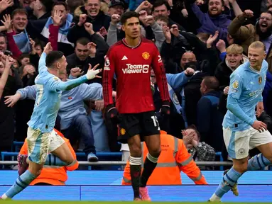 Reaksi pemain Manchester United Raphael Varane (tengah) saat Erling Haaland (kanan) dan Phil Foden merayakan gol ketiga Manchester City pada pertandingan sepak bola Liga Premier Inggris di Stadion Etihad, Manchester, Inggris, Minggu, 3 Maret 2024. (AP Photo/Dave Thompson)