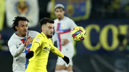 Bek Barcelona, Jules Kounde berusaha merebut bola dari pemain Villarreal, Alex Baena selama pertandingan lanjutan La Liga Spanyol di stadion Ceramica di Villarreal, Spanyol, Senin (13/2/2023). Barcelona berada di pucuk dengan koleksi 56 poin, unggul 11 poin atas tim peringkat kedua Real Madrid, namun Los Blancos baru memainkan 20 pertandingan. (AP Photo/Alberto Saiz)