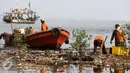 Petugas mengunakan perahu mengangkut sampah di pesisir Muara Angke, Jakarta, Kamis (29/10). Setiap harinya mereka yang digaji UMR berkeliling membersihkan sampah yang terbawa arus laut maupun aliran sungai Kanal Banjir Barat. (Liputan6.com/Faizal Fanani)
