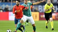 Gelandang Spanyol, Isco (kiri), tengah berusaha mempertahankan bola dari gelandang Jerman, Sami Khedira, saat kedua tim bersua pada laga uji coba, di Stadion ESPRIT arena, Jumat (23/3/2018). (AP Photo/Martin Meissner).