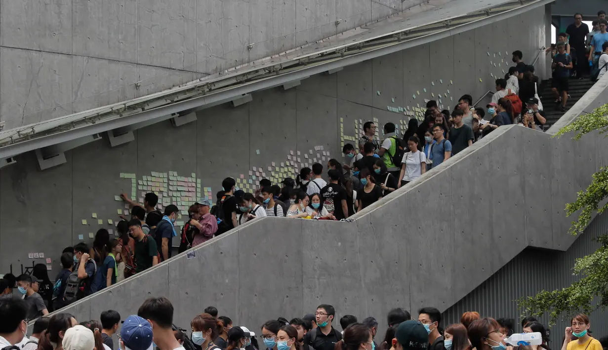 Pengunjuk rasa melewati tangga saat berkumpul di luar gedung parlemen di Hong Kong, Rabu (12/6/2019). Ribuan pengunjuk rasa memblokir pintu masuk ke kantor pusat pemerintah Hong Kong untuk memprotes RUU Ekstradisi. (AP Photo/Kin Cheung)