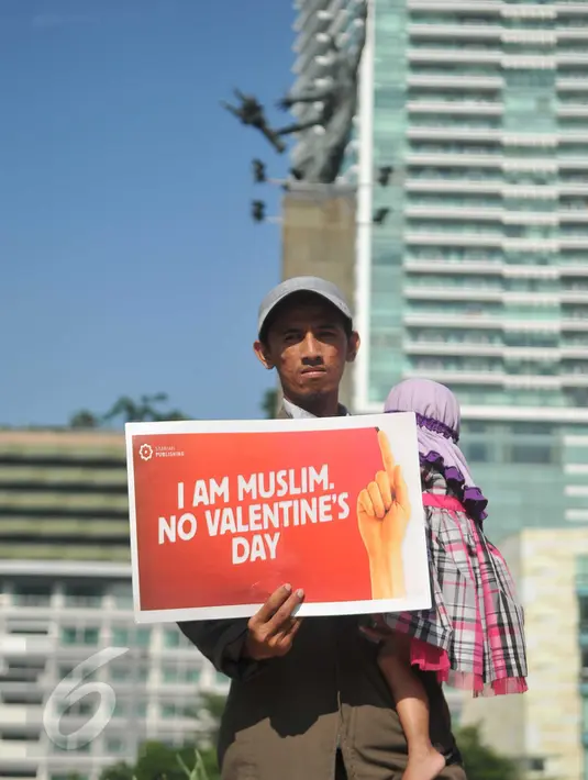 Seorang lelaki menggendong bayi ikut menolak Valentine Day di Kawasan Bundaran HI, Jakarta, Minggu (14/2/2016). Mereka menilai perayaan Valentine Day kerap menjurus pada perilaku seks bebas dan merusak moral. (Liputan6.com/Gempur M Surya)