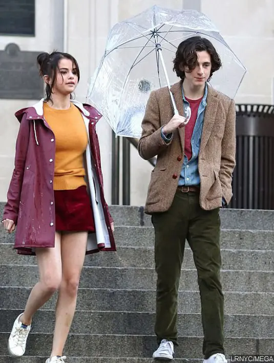 Selena Gomez, mengganti pakaiannya dengan memakai sweater berwarna kuning, rok mini corduroy berwarna maroon, serta rain jaket berwarna magenta. Sungguh menggemaskan, bukan? (Doc. Ace Showbiz)