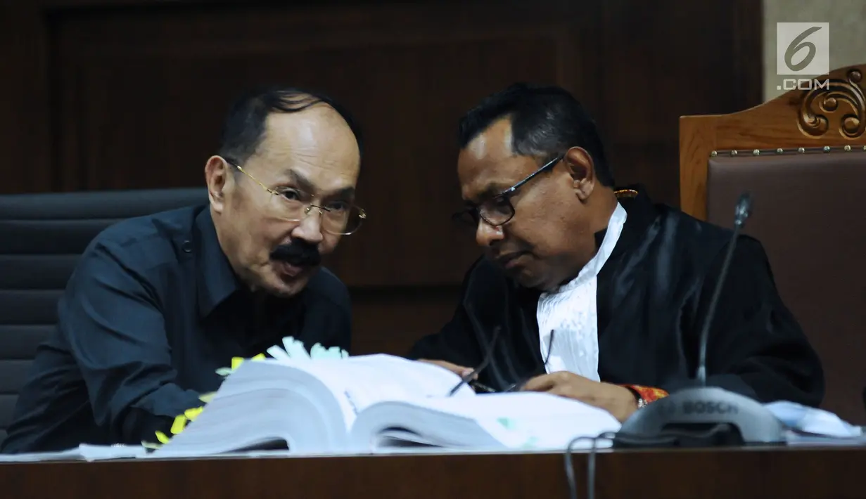 Terdakwa kasus dugaan merintangi penyidikan dugaan korupsi e-KTP, Fredrich Yunadi (kiri) berbincang dengan penasehat hukumnya saat menyimak keterangan saksi di sidang lanjutan di Pengadilan Tipikor, Jakarta, Kamis (15/3). (Liputan6.com/Helmi Fithriansyah)