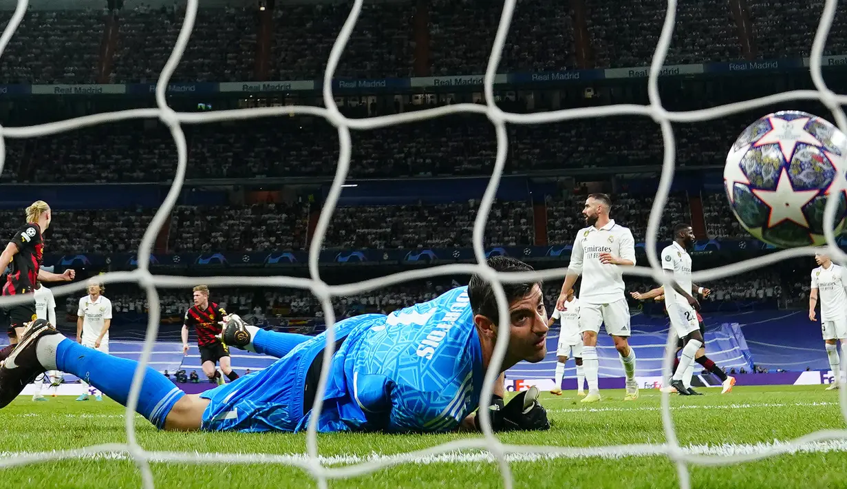 Penjaga gawang Real Madrid, Thibaut Courtois (tengah), gagal menghalau tendangan pemain Manchester City, Kevin De Bruyne, dalam pertandingan leg pertama Liga Champions 2022/2023 yang berlangsung di Santiago Bernabeu stadium, Rabu (10/5/2023) dini hari WIB. (AP Photo/Manu Fernandez)