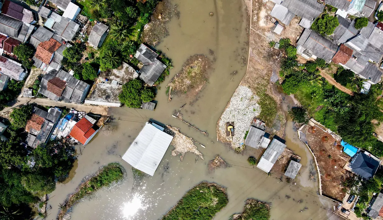 Foto udara menunjukkan pemandangan rumah-rumah penduduk dan jalan yang terendam air akibat luapan sungai sebagai dampak longsornya tumpukan sampah yang menyumbat aliran sungai di Depok pada 7 Mei 2024. (BAY ISMOYO/AFP)