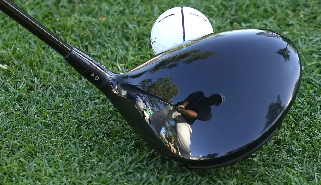 Refleksi pegolf Korea Selatan, Tom Kim di tongkat golf saat akan melakukan pukulan ke hole ke-18 selama putaran pertama turnamen Golf Masters 2024 di Augusta National Golf Club, Agusta, Georgia, Jumat (12/04/2024). (AP Photo/Matt Slocum)