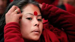 Ekspresi wajah seorang wanita Hindu Nepal saat mengikuti upacara Madhav Narayan di Kathmandu, Nepal (27/1). Dalam upacara ini mereka juga membaca kitab suci yang dipersembahkan untuk dewi Hindu Swasthani dan dewa Hindu Siwa. (AP Photo/Niranjan Shrestha)