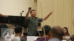 Konduktor Avip Priatna berlatih bersama Jakarta Concert Orchestra dan Batavia Madrigal Singers di Jakarta (8/11). Pertunjukan musik pilihan bertajuk Hymn of Praise akan digelar di Aula Simfonia Jakarta 12 Desember mendatang. (Liputan6.com/Fery Pradolo)