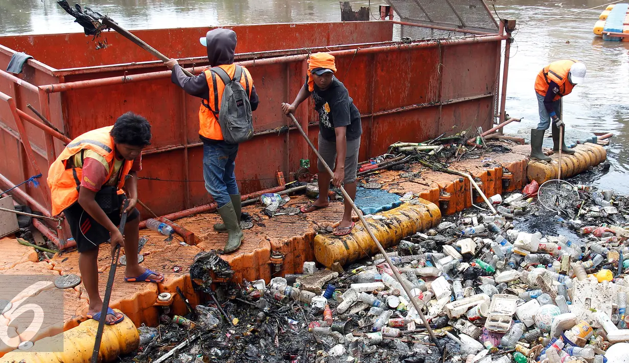 Petugas membersihkan sampah di Pintu Air Jembatan Hanging, Jakarta, Jum'at (30/9). Pembersihan tersebut selain sebagai perawatan pintu air Jembatan Hanging juga untuk mengurangi bahaya banjir. (Liputan6.com/Johan Tallo)
