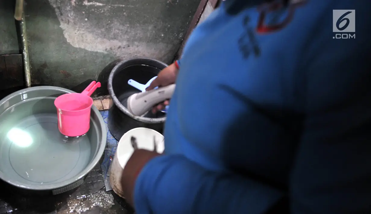 Petugas memeriksa keberadaan jentik nyamuk dalam bak mandi warga di kawasan Duren Sawit, Jakarta, Rabu (27/2). Penijauan Jumantik yang dilakukan rutin setiap minggunya ini bertujuan mencegah berkembangbiaknya nyamuk demam. (Merdeka.com/Iqbal S. Nugroho)