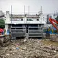 Petugas dibantu alat berat membersihkan sampah kayu dan bambu yang tersangkut di Pintu Air Manggarai, Jakarta, Rabu (9/10/2019). Sekitar 80 ton sampah sudah diangkut menggunakan alat berat. (Liputan6.com/Faizal Fanani)