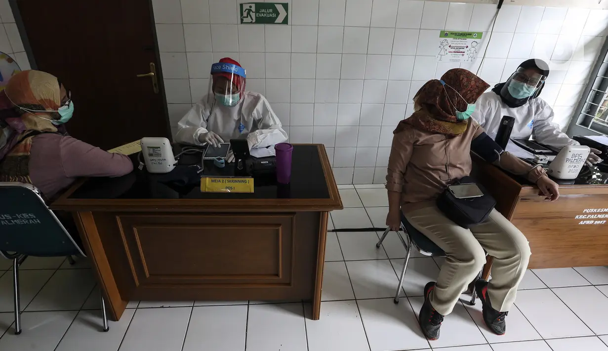 Petugas medis memeriksa kondisi tenaga kesehatan sebelum disuntik vaksin COVID-19 Sinovac di Puskesmas Palmerah, Jakarta, Kamis (28/1/2021). Pemberian vaksin COVID-19 tahap kedua dilaksanakan terhadap tenaga kesehatan mulai hari ini. (Liputan6.com/Johan Tallo)