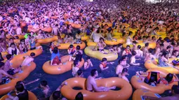 Corona Berlalu, Warga Wuhan Pesta di Kolam: Orang-orang menonton pertunjukan musik sambil bermain air di sebuah taman air atau water park di Wuhan, provinsi Hubei, China, 15 Agustus 2020. Mereka berpesta saat Wuhan kembali ke kehidupan normal setelah sempat terdampak parah oleh COVID-19. (STR/AFP)