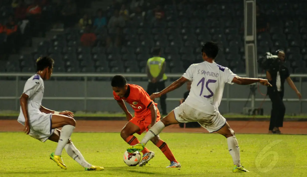 Gelandang Persija, Ramdani Lestaluhu (tengah) mencoba menerobos hadangan dua pemain Persik Kediri saat berlaga di stadion GBK Jakarta, (30/5/2014). (Liputan6.com/Helmi Fithriansyah)
