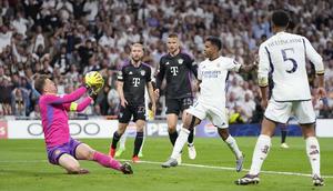 Kiper Bayern Munchen, Manuel Neuer (kiri) berhasil menangkap bola tendangan striker Real Madrid, Rodrygo (tengah) pada laga leg kedua semifinal Liga Champions 2023/2024 di Santiago Bernabeu Stadium, Madrid, Rabu (8/5/2024). (AP Photo/Manu Fernandez)