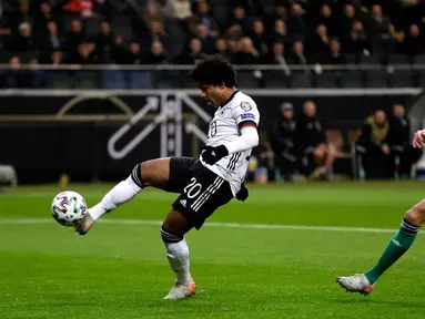 Gelandang Timnas Jerman, Serge Gnabry mengontrol bola dengan dibayangi pemain Irlandia Utara pada laga Grup C Kualifikasi Piala Eropa 2020 di Commerzbank Arena, Selasa (19/11/2019). Timnas Jerman benamkan Irlandia Utara dengan skor telak 6-1 berkat bantuan hat-trick dari Gnabry. (AP/Michael Probst)