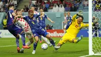 Kiper Jepang,&nbsp;Shuichi Gonda (kanan) berusaha menghalau bola saat laga 16 besar Piala Dunia 2022 melawan Kroasia di Al Janoub Stadium, Senin (05/12/2022). (AP/Francisco Seco)