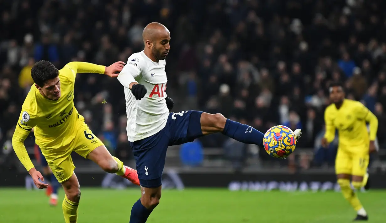Gelandang Tottenham Hotspur Lucas Moura (tengah) bersaing dengan gelandang Brentford Christian Norgaard dalam lanjutan Premier League di Tottenham Hotspur Stadium, Jumat (3/12/2021) dini hari WIB. Tottenham Hotspur berhasil mengalahkan Brentford dengan skor 2-0. (Daniel LEAL/AFP)