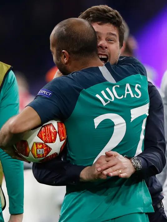 Pemain Tottenham Hotspur, Lucas berselebrasi dengan manajer Mauricio Pochettino usai menang atas Ajax Amsterdam pada akhir laga kedua semifinal Liga Champions 2018/19 di Stadion Johan Cruyff, Rabu (8/5). Tottenham melaju ke Final Liga Champions usai mengalahkan Ajax 3-2. (Adrian DENNIS / AFP)