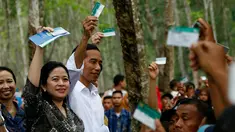 Menko Bidang Pembangunan Manusia dan Kebudayaan, Puan Maharani mendampingi Presiden Joko Widodo membagikan Kartu Indonesia Sehat kepada para pekerja di Kabupaten Deli Serdang, Sumatera Utara, Sabtu (18/4). (Liputan6.com/Pool)