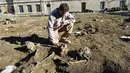 Seorang Arkeologi Investigasi "Hades", Xavier Perrot mengangkat sisa-sisa kerangka, tengkorak dan tulang yang nantinya akan diteliti di daerah pemakaman kuno di Bordeaux, Prancis (6/12). (AFP/Georges Gobet)