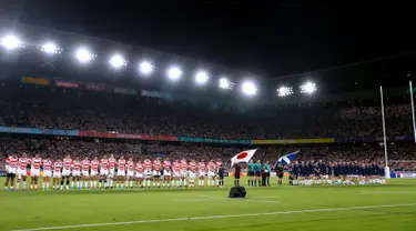 Pemain rugby Jepang dan Skotlandia berdoa bersama selama satu menit untuk korban Topan Hagibis sebelum Pertandingan Pool A Piala Dunia Rugbi 2019 di Stadion Internasional Yokohama (13/10/2019). (AFP Photo/Odd Andersen)